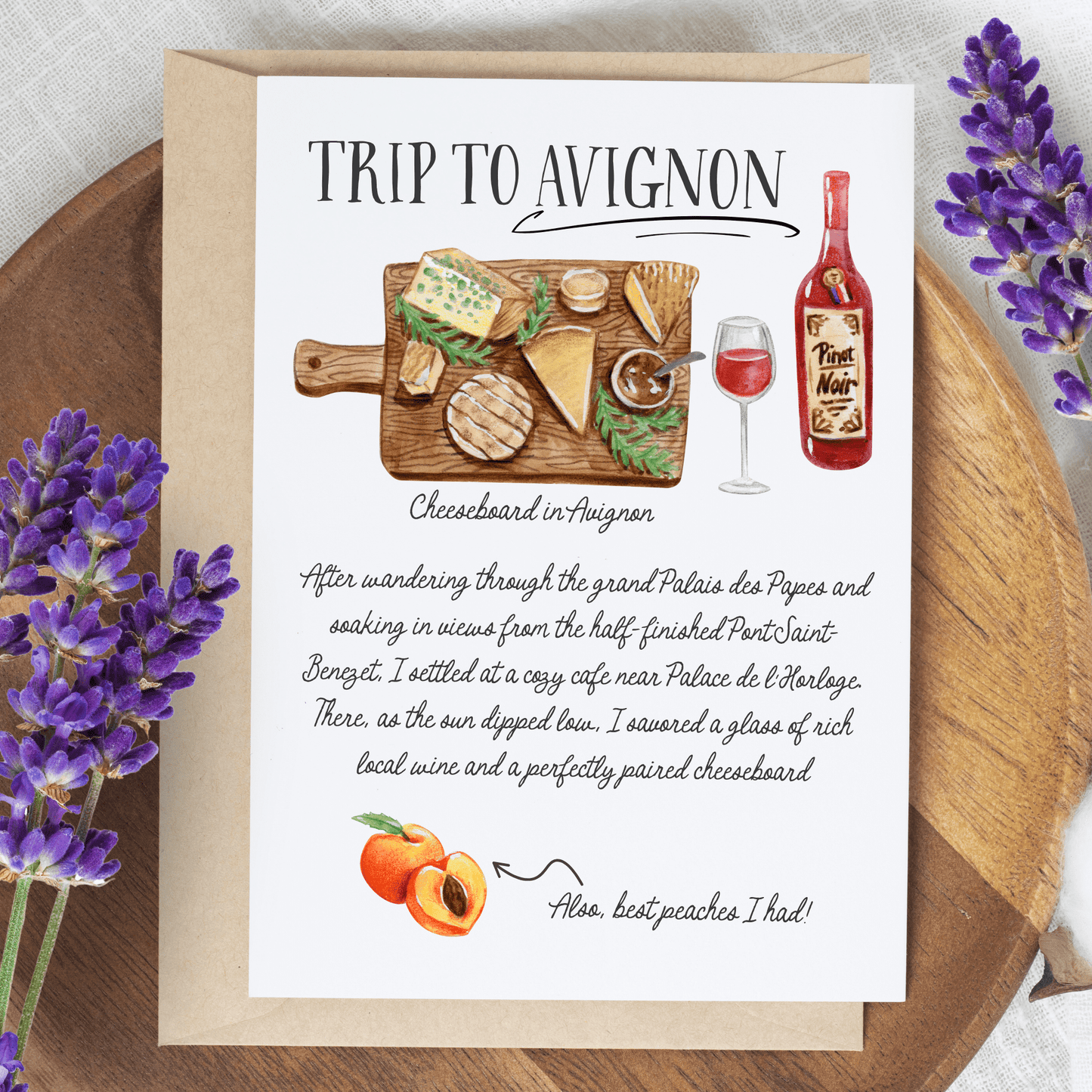 Greeting card with illustration of cheeseboard and wine bottle, set on a wooden surface with lavender.
